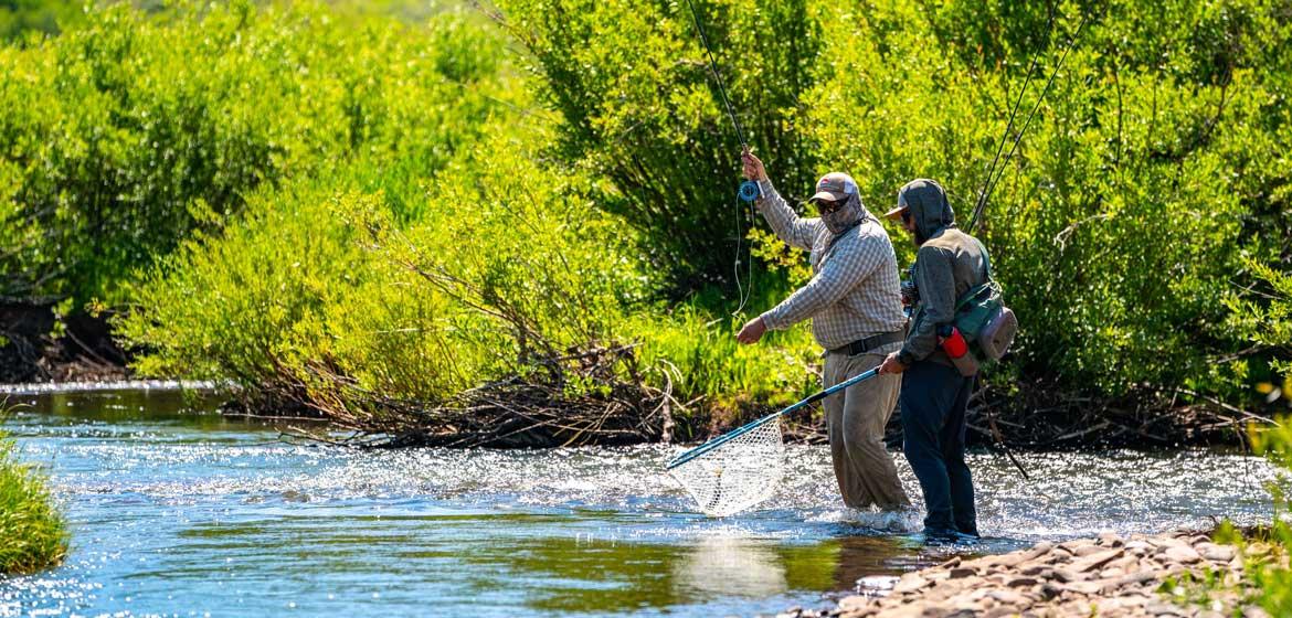 Two people fly fishing on a river in Utah