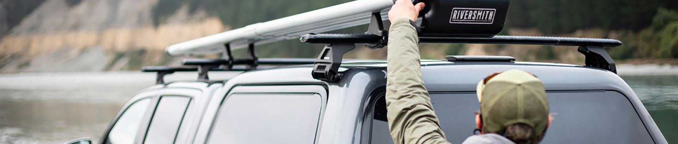 An angler unloading his fly fishing rods from his truck-top Riversmith River Quiver.