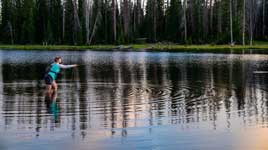 An angler casting to rising fish during the evening hatch at Crystal Lake, a popular destination for anglers visiting the Uinta National Forest.