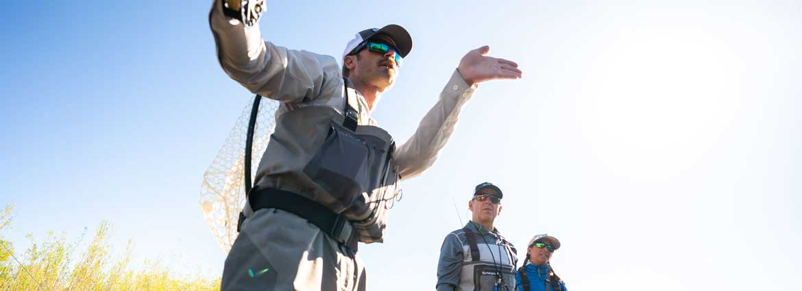 A closeup of two anglers tying on flies on a river in Northern Utah