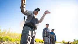 A closeup of two anglers tying on flies on a river in Northern Utah