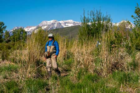 An angler walks down to the river on the Lower Provo River in Utah.