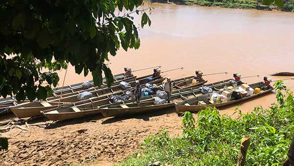 A row of 3 dug out canoes ready to take the anglers up the river to the lodge