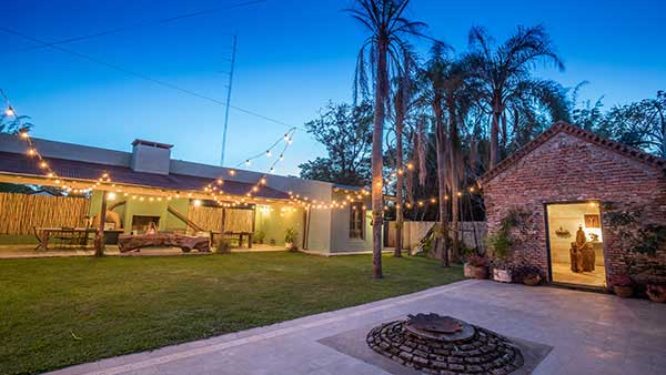 La Alondra lodge at dusk with string lights and the firepit 