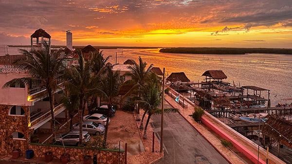 An arial view of the Tarpon Cay Lodge at sunset and the crystal-clear Caribbean waters found in Rio Llagartos, Mexico.