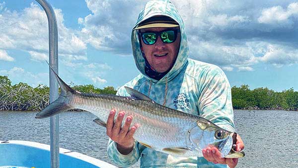 Fishwest Travel Director, JC Weeks showcasing a tarpon (sabalo) caught on a recent trip to Xcalak with Fishwest.